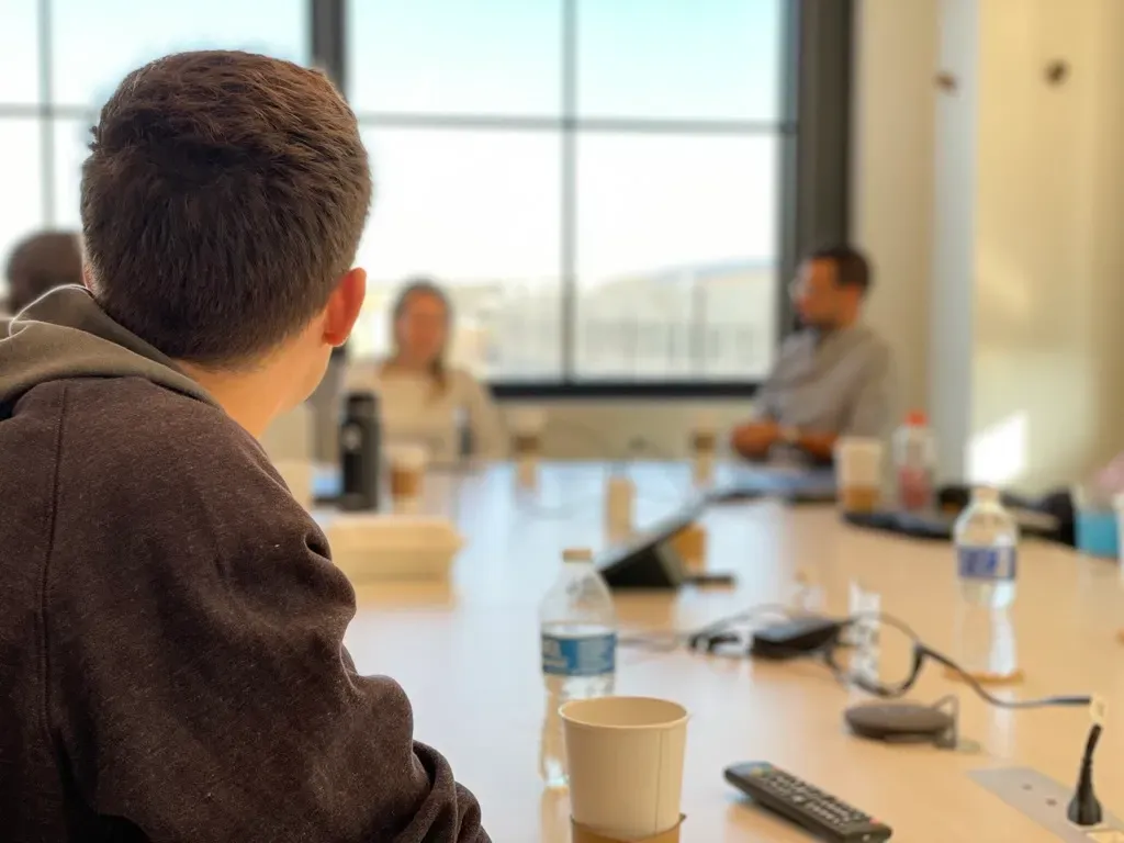 Person looking towards a group of people having a meeting
